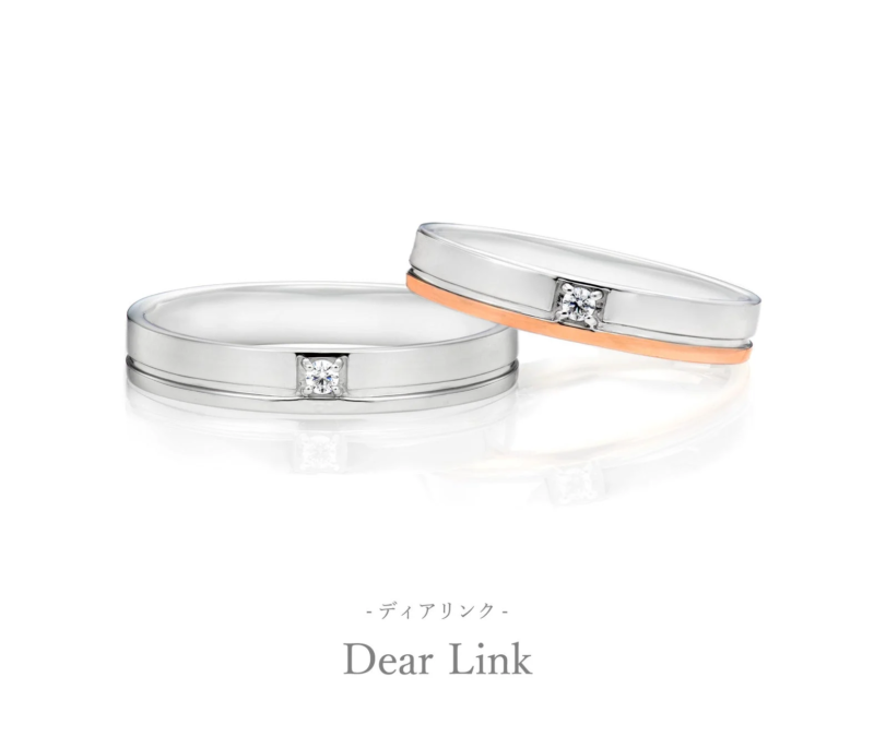 白い背景に、ダイヤモンドが埋め込まれた2つの結婚指輪が写っています