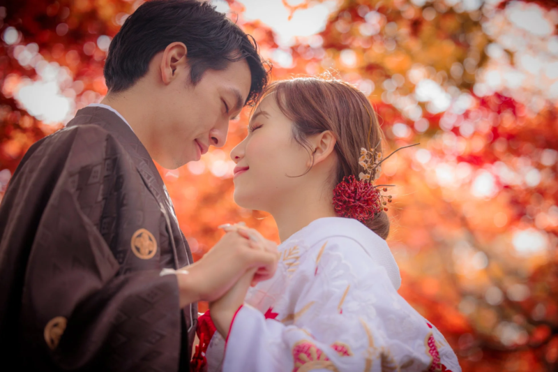 和装のカップルが紅葉の中で見つめ合うロマンチックなポートレート