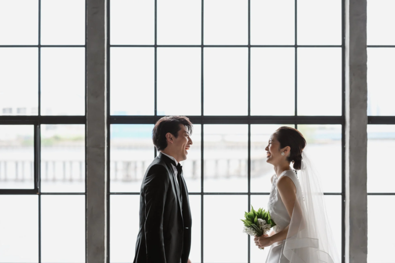 窓辺で微笑む新郎新婦