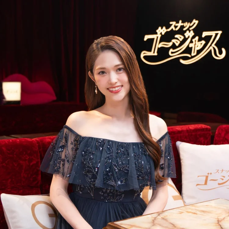 オフショルダーのネイビーのドレスを着て笑顔を見せる松村沙友理さん