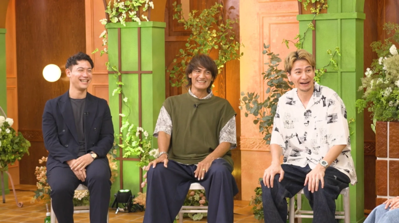 笑顔で会話する男性3人組
