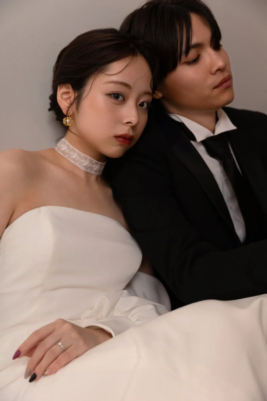 フォーマルな衣装を身につけたカップルが寄り添うポートレート。