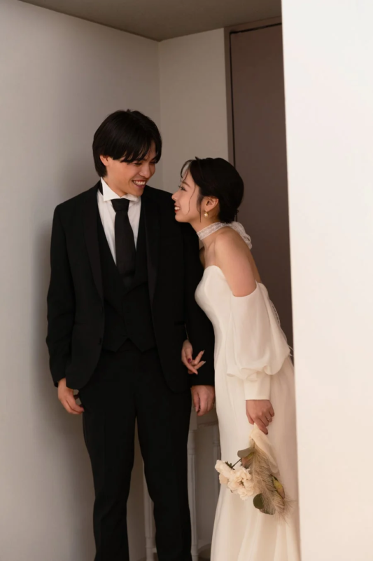 新郎新婦が互いに見つめ合い、幸せそうな笑顔を浮かべている美しいウェディングフォト。