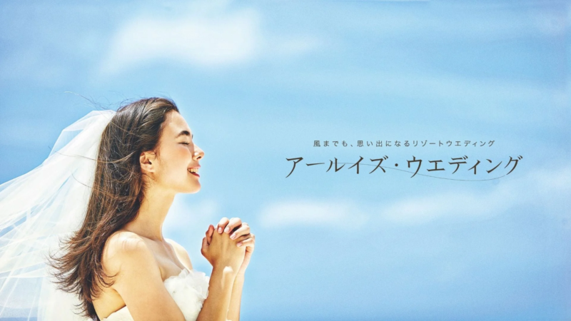 青空の下、白いベールをなびかせ微笑む花嫁